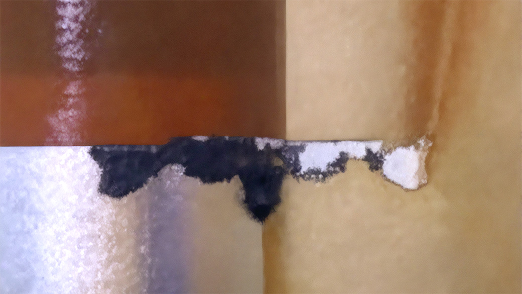 Teardown photograph showing puncture marks and burning at the foil edges
